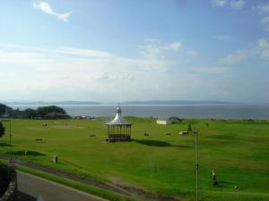 un campo con un cenador en medio de un campo en The Bandstand, en Nairn