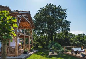 a garden with a wooden pavilion next to a house at Domaine de Terrac in Rimont