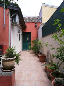 a courtyard with potted plants and a green door at Casa e Giardino in San Giovanni la Punta