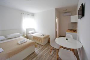 een kleine kamer met 2 bedden en een tafel bij Apartment Kate in Bibinje