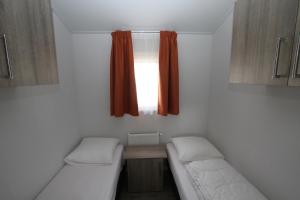 Molkwerum的住宿－IJsselmeer-chalet nr. 66，小房间设有两张床和窗户
