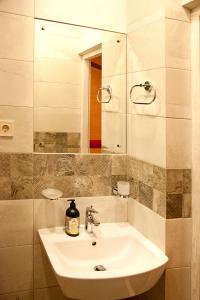 bagno con lavandino bianco e specchio di Apartment in Deribasovskaya street 13 a Odessa