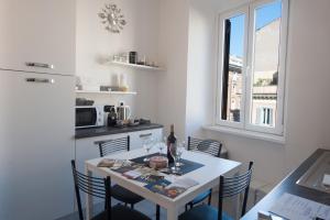 cocina con mesa con sillas y ventana en Nazionale 221 Luxury Home, en Roma
