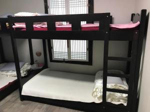 a black bunk bed with two sets of bunk beds at Guesthouse Nabiya in Chuncheon