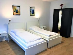 2 camas en una habitación con una cruz en la pared en Ferienwohnung Neuss, en Neuss