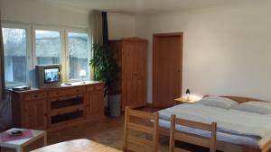 1 dormitorio con 1 cama, TV y mesa en Hotel Landhaus Leuchtfeuer Nordseeinsel Pellworm en Pellworm
