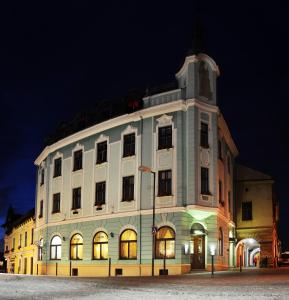 a large white building with a clock tower at night at Hotel Růžek in Hranice