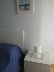 パストレンゴにあるAppartamenti Di Lauraのベッドルーム1室(ベッド1台、ナイトスタンドのランプ付)