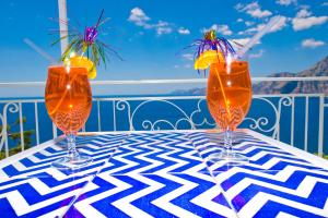 3 verres à vin assis sur une table sur un balcon dans l'établissement Il Corallo, à Praiano