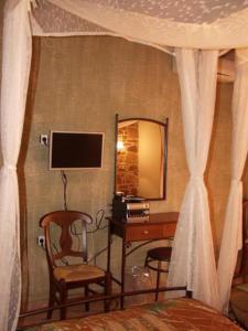 1 dormitorio con cama, escritorio y espejo en Manganos Apartments, en Kambos