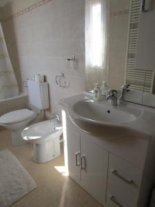 bagno bianco con lavandino e servizi igienici di Appartamenti Di Laura a Pastrengo