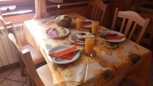 una mesa con platos de comida y zumo de naranja. en Gostišče Hedvika, en Kal-Koritnica