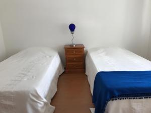 two twin beds in a room with a dresser at Europa Apart in Castanheira de Pêra