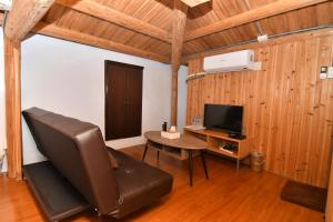 a living room with a leather chair and a television at 芹壁德順號民宿Chinbe D S House B&B in Beigan