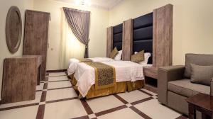 艾卜哈的住宿－Rose Palace For Residential Units，一间卧室配有一张大床和一把椅子