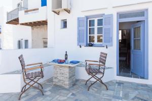 a patio with two chairs and a table with a bottle of wine at Aris & Maria Houses in Kastron