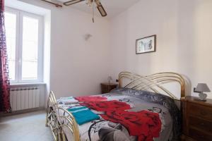 a bedroom with a bed with a red dragon blanket on it at Casa Beverini in La Spezia