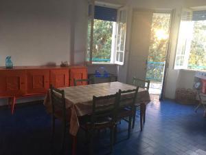 a dining room with a table and chairs and windows at Blu Mare Villa Carlo in Anzio