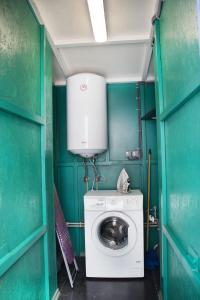 a washing machine in a room with green walls at Dacha v Odesse in Odesa +8 photos