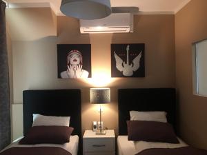 a bedroom with two beds and two pictures on the wall at Royal Apartments & Rooms in Zagreb
