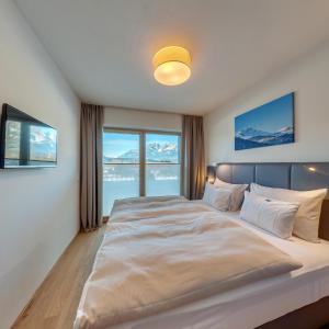 ein Schlafzimmer mit einem großen Bett und einem großen Fenster in der Unterkunft das Stefan - Ferienwohnungen in den Kitzbüheler Alpen in Oberndorf in Tirol
