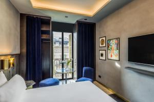 a hotel room with a bed and a flat screen tv at Room Mate Collection Gerard, Barcelona in Barcelona +50 photos