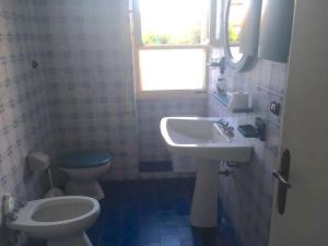 y baño con aseo y lavamanos. en Blu Mare Villa Carlo, en Anzio