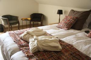 a bed with a blanket on it with two chairs at De Rankhove in Herne