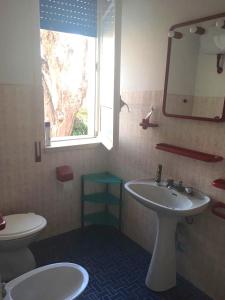 baño con lavabo y aseo y ventana en Blu Mare Villa Carlo, en Anzio