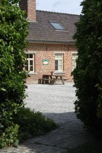 een bakstenen huis met een picknickbank ervoor bij De Rankhove in Herne