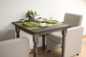 een eettafel met 2 stoelen en een houten tafel met glazen bij De Rankhove in Herne