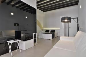 a living room with a bed and a couch at Lonja Suites Apartments in Palma de Mallorca