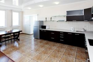 a large kitchen with a table and a refrigerator at Botanic Apartments in Kyiv
