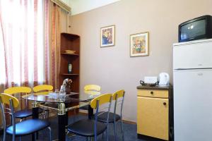 ein Esszimmer mit einem Tisch und einem Kühlschrank in der Unterkunft Home Hotel Apartments on Lva Tolstogo in Kiew