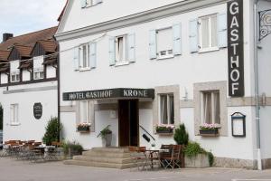 a white building with tables and chairs in front of it at Hotel Gasthof Krone in Zusmarshausen