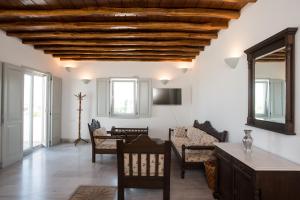 a living room with white walls and a wooden ceiling at Bleland Mykonos in Mikonos