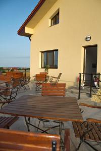 a group of wooden tables and chairs in front of a building at Casa La Flori in Techirghiol