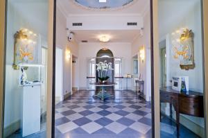 korytarz z podłogą wyłożoną szachownicą i lustrem w obiekcie Hotel De Paris Sanremo w San Remo