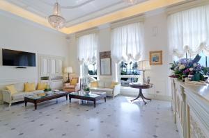 a large living room with white furniture and a chandelier at Hotel De Paris Sanremo in Sanremo