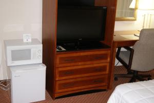 a television on a wooden dresser in a hotel room at Motel 6 Hastings NE in Hastings