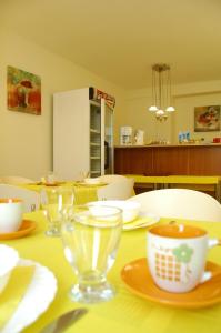 a table with glasses and plates and a cup on it at Villa Nevenka Rooms in Belgrade