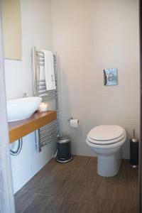 a bathroom with a white toilet and a sink at Varkiza Luxury Residence in Varkiza