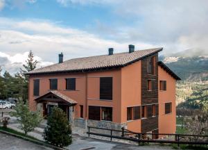 una casa con una montagna sullo sfondo di Alberg Cal Manel a Saldes