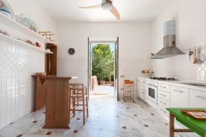レウカにあるVilla Merienne by BarbarHouseの白い壁のキッチン、天井ファンが備わります。