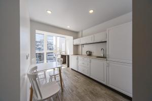 a kitchen with white cabinets and a table and chairs at Partner Guest House in Kyiv