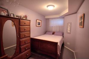 Dormitorio pequeño con cama y vestidor en Hummingbird Bed and Breakfast en Clearwater