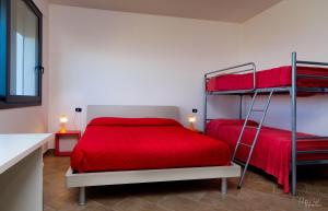 a bedroom with two bunk beds with red sheets at Su AlevraXi in Villagrande Strisaili