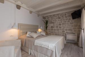 a bedroom with a bed and a stone wall at Dubrovnik Sweet House in Dubrovnik