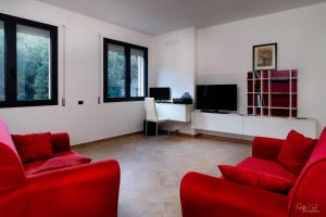 sala de estar con 2 sillas rojas y escritorio en Su AlevraXi, en Villagrande Strisaili