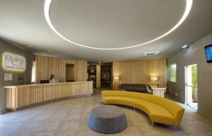 a lobby with a yellow couch and a table at 3HB Falésia Mar in Albufeira